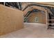 An unfinished attic area with exposed wood frame, vents, insulation, and a small window at 100 Carol Cir, Louisburg, NC 27549