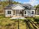 The rear of a single story home with a screened-in porch, grey siding, and a grassy backyard at 100 Carol Cir, Louisburg, NC 27549
