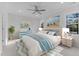 Comfortable bedroom with large windows, soft carpet, coastal artwork, and a ceiling fan at 100 Carol Cir, Louisburg, NC 27549