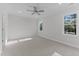 Large bedroom with carpet, ceiling fan and two large windows at 100 Carol Cir, Louisburg, NC 27549