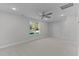 A well lit carpeted bedroom with a window, ceiling fan, recessed lights and light grey walls at 100 Carol Cir, Louisburg, NC 27549