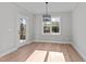 Bright dining room with hardwood floors, natural light, designer chandelier, and access to outdoor deck at 100 Carol Cir, Louisburg, NC 27549