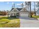 Charming front exterior view of the home featuring a two-car garage and well-manicured lawn at 100 Carol Cir, Louisburg, NC 27549