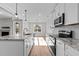 Modern kitchen with white cabinets, granite countertops, stainless steel appliances, and wood flooring at 100 Carol Cir, Louisburg, NC 27549