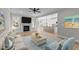 Bright living room featuring fireplace, wood floors, modern ceiling fan and open floorplan with kitchen bar and dining area at 100 Carol Cir, Louisburg, NC 27549