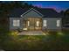 View of the home's rear exterior featuring a screened-in porch, concrete patio, and level backyard at 100 Carol Cir, Louisburg, NC 27549