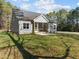 Angled view of the home's rear exterior, highlighting the screened-in porch and spacious lawn at 100 Carol Cir, Louisburg, NC 27549