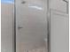 The tiled shower features a glass door, bench, and a horizontal window at 100 Carol Cir, Louisburg, NC 27549