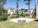 Rear view of home, featuring a patio area, fire pit, and lush landscaping at 123 Cottage Way, Pittsboro, NC 27312