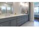 Modern bathroom featuring gray cabinets with double sinks, white quartz countertops, and marble floors at 123 Cottage Way, Pittsboro, NC 27312