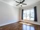 This well-lit bedroom boasts hardwood floors, a ceiling fan, and a large window for a bright and airy feel at 123 Cottage Way, Pittsboro, NC 27312