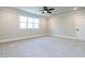Spacious bedroom with neutral carpet, ceiling fan, large window, and white trim, offering a relaxing retreat at 123 Cottage Way, Pittsboro, NC 27312