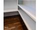 This walk-in closet is designed with white shelves and hardwood floors for ample storage and style at 123 Cottage Way, Pittsboro, NC 27312