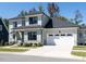 Beautiful two story home featuring professional landscaping, a large garage and grey exterior paint at 123 Cottage Way, Pittsboro, NC 27312