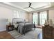 Comfortable bedroom with a metal bed frame, ceiling fan, neutral colored walls, and natural lighting at 123 Cottage Way, Pittsboro, NC 27312