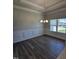 Dining room featuring wood floors, modern chandelier, wainscoting, and natural light from a large window at 28 Decatur Dr, Fuquay Varina, NC 27526