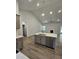 Kitchen island featuring quartz countertops, stainless steel sink, seating, and view of the living room at 28 Decatur Dr, Fuquay Varina, NC 27526