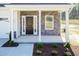 Front porch with stone columns, a dark front door, and new landscaping at 42 Decatur Dr, Fuquay Varina, NC 27526