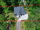 Aerial view of a modern, two-story home among lush trees, showcasing the roof and driveway at 5406 Garrett Rd, Durham, NC 27707