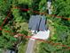 Aerial view showcasing a modern home surrounded by lush greenery, with driveway and neighboring houses visible at 5406 Garrett Rd, Durham, NC 27707
