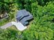 An aerial shot showcasing a roof of a two-story home nestled in lush greenery with a modern driveway design at 5406 Garrett Rd, Durham, NC 27707