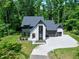 An aerial view of a two-story home surrounded by green trees, showing the driveway and manicured lawn at 5406 Garrett Rd, Durham, NC 27707