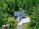 Overhead shot of a two-story home with a manicured lawn, concrete driveway, and surrounded by a dense forest at 5406 Garrett Rd, Durham, NC 27707