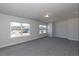 An expansive bonus room with carpeted floors and plenty of natural light from two windows at 56 Decatur Dr, Fuquay Varina, NC 27526