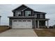 Two-story home with gray siding, a two-car garage, a concrete driveway, and a landscaped yard at 56 Decatur Dr, Fuquay Varina, NC 27526