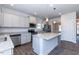 Bright kitchen with stainless steel appliances, island with light granite countertop, and gray cabinets at 56 Decatur Dr, Fuquay Varina, NC 27526