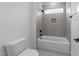 Modern bathroom with gray tile, a shower and bath combination, and sleek fixtures at 30 Spanish Oak Dr, Youngsville, NC 27596