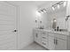 Beautiful bathroom featuring a double vanity with modern fixtures, a large mirror, and neutral tile flooring at 30 Spanish Oak Dr, Youngsville, NC 27596