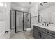 Modern bathroom featuring a large glassed shower with chandelier shower head, gray vanity, and modern faucet at 30 Spanish Oak Dr, Youngsville, NC 27596