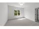 Bright bedroom featuring neutral carpet, a modern light fixture, and natural light from a window at 30 Spanish Oak Dr, Youngsville, NC 27596