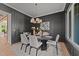 Elegant dining room with dark paneled walls, a modern chandelier, and seating for six at 30 Spanish Oak Dr, Youngsville, NC 27596