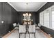 Elegant dining room with dark paneled walls, a modern chandelier, and seating for six at 30 Spanish Oak Dr, Youngsville, NC 27596