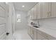 Well-lit laundry room with cabinets, sink, modern fixtures, and patterned tile floor at 30 Spanish Oak Dr, Youngsville, NC 27596