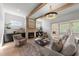 Inviting living room features a stone fireplace, wood beams, and sliding glass doors to a spacious deck at 30 Spanish Oak Dr, Youngsville, NC 27596