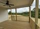 View of wooden deck with ceiling fan overlooking lush green scenery and rolling hills at 85 Claude Creek Way, Smithfield, NC 27577