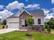 Charming home featuring a stone archway, two-car garage, and a well-manicured lawn at 85 Claude Creek Way, Smithfield, NC 27577