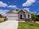 Charming home featuring a stone archway, two-car garage, and a well-manicured lawn at 85 Claude Creek Way, Smithfield, NC 27577