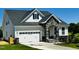 A charming home featuring stone accents, white siding, and a convenient two-car garage at 85 Claude Creek Way, Smithfield, NC 27577