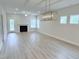 Spacious living room features modern light fixture, luxury vinyl flooring and a cozy fireplace at 85 Claude Creek Way, Smithfield, NC 27577