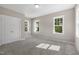 Bright carpeted bedroom with multiple windows and a closet at 1029 Whitehall Cir, Durham, NC 27713