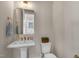 Half bathroom features a sleek pedestal sink, gold fixtures, and ample lighting at 1029 Whitehall Cir, Durham, NC 27713