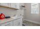 Well-lit laundry room featuring a large utility sink, white cabinetry, and neutral countertops at 1029 Whitehall Cir, Durham, NC 27713