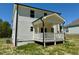 View of the back of the house with a small porch and grass yard at 199 Grand Griffon Way, Lillington, NC 27546