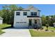 Two-story white home with stone accents, two car garage, and modern black shutters at 199 Grand Griffon Way, Lillington, NC 27546