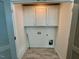 Compact laundry room with tile floors, cabinet storage, and washer/dryer hookups at 199 Grand Griffon Way, Lillington, NC 27546