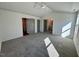 Spacious main bedroom featuring neutral walls and carpet, ceiling fan, and ensuite bathroom entrance at 199 Grand Griffon Way, Lillington, NC 27546